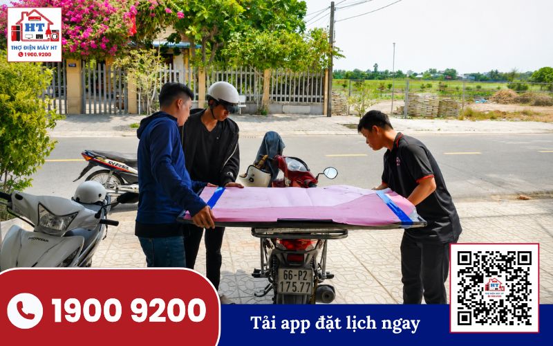 Kỹ thuật viên Hệ Thống Điện Tử HT vận chuyển tivi sau khi hoàn tất sửa chữa